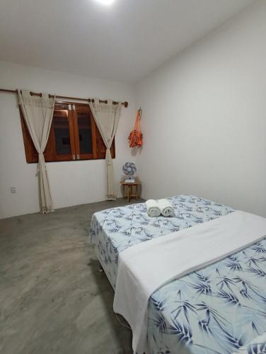 a bedroom with a bed with blue and white sheets at Casa Teodoro!!! in Trairi