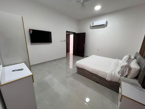 - une chambre avec un lit et une télévision à écran plat dans l'établissement Red-3 - New Salalah, à Salalah