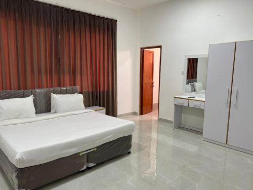 Il comprend une chambre avec un grand lit et une cuisine. dans l'établissement Red-3 - New Salalah, à Salalah