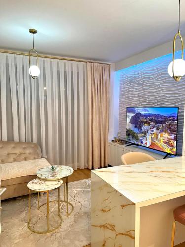 ein Wohnzimmer mit Sofa und Fernseher in der Unterkunft Coral in Sarajevo