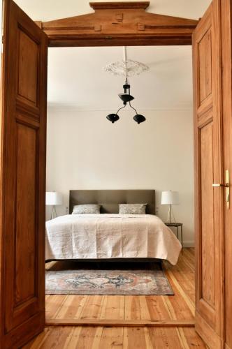 a bedroom with a bed and a chandelier at Żeromskiego Residence in Słupsk