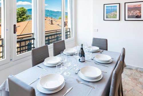 a dining room with a table with plates and wine glasses at Labiena Lake Maggiore in Laveno