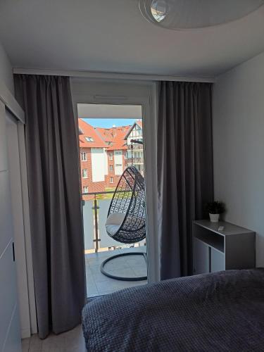 um quarto com uma cama e vista para uma varanda em Apartament Baltic Garden Sztutowo em Sztutowo