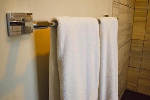 two white towels hanging on a towel rack in a bathroom at Hotel Venedik in Veracruz