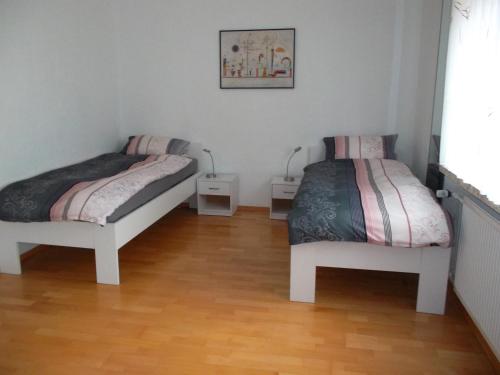 um quarto com 2 camas e piso em madeira em Ferienwohnung Jürges em Northeim