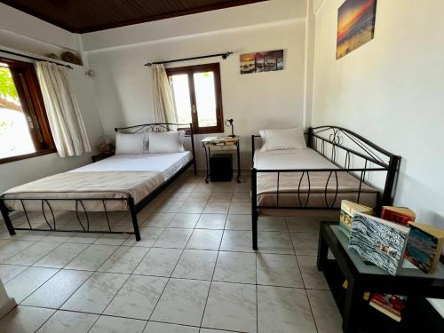 a bedroom with two beds and a table at Anestis Ioanna Villa in Daratso