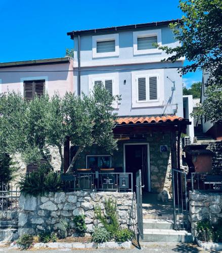 a house with a stone wall in front of it at Kuća za odmor “Dida” in Stinica