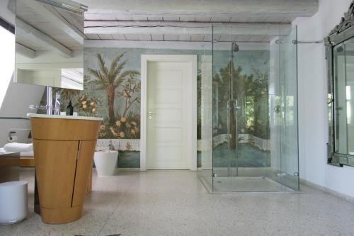 La salle de bains est pourvue d'une douche et d'une porte en verre. dans l'établissement villaflora Gästehaus, à Riedlingen
