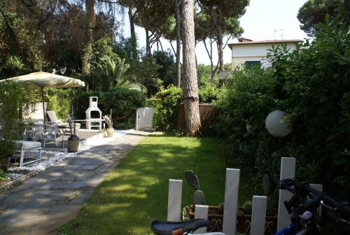 a garden with a lawn with a fence and trees at DomusAuroom, il tuo RELAX in Viareggio
