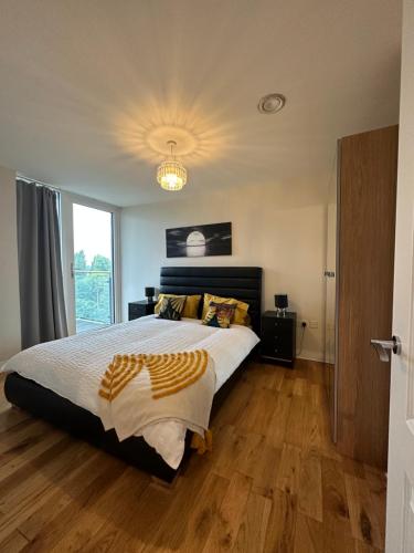 ein Schlafzimmer mit einem großen Bett und einem großen Fenster in der Unterkunft Uxbridge Apartment in Uxbridge