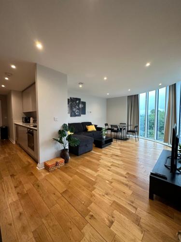 ein großes Wohnzimmer mit einem Sofa und einem Tisch in der Unterkunft Uxbridge Apartment in Uxbridge