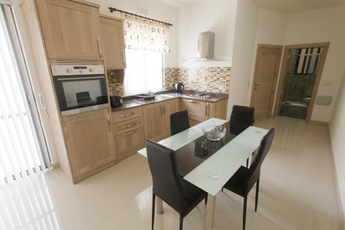 cocina con mesa y sillas en Waterside Apartments, en Marsalforn