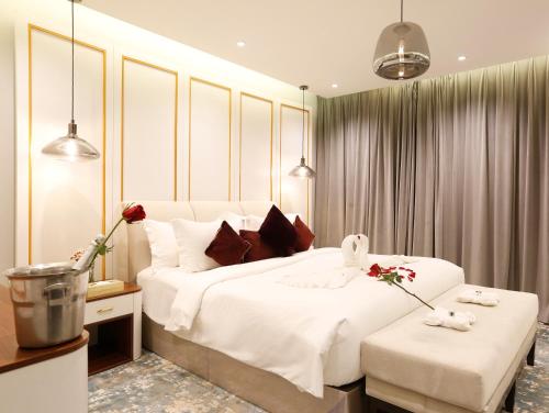 a bedroom with a large white bed with two stools at شقق القمر الأبيض للشقق المخدومة in Khamis Mushayt