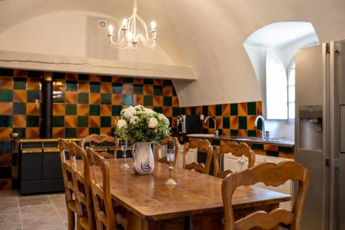 a kitchen with a wooden table with a vase of flowers at Château Saint-Pierre de Mejans in Puyvert