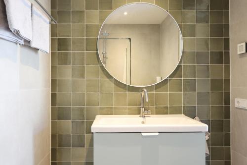 ein Bad mit einem Waschbecken und einem Spiegel in der Unterkunft Zilt aan Zee in Egmond aan Zee