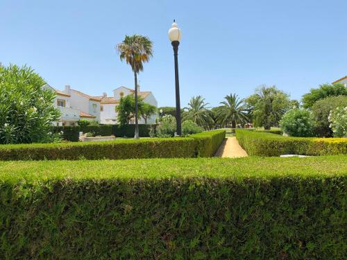 un parque con arbustos, un semáforo y palmeras en NOVO SANCTI PETRI - CASA CON ENCANTO en Novo Sancti Petri