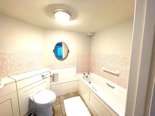 Minehead mews cottage في مينهيد: حمام مع مرحاض وحوض استحمام ومغسلة