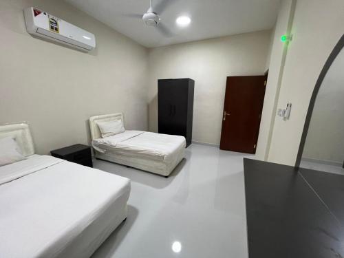 a hotel room with two beds and a room with aacoustic at Red 8 - OKAAD in Salalah