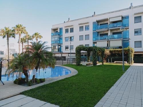 een appartementencomplex met een zwembad en palmbomen bij Residencial la Bahía in Santa Pola