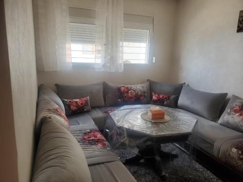 ein Wohnzimmer mit einem Sofa und einem Tisch in der Unterkunft Joli appartement in Agadir