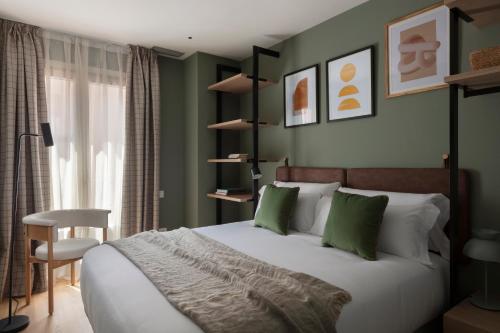 a bedroom with a bed with green walls and a chair at TOC Hotel Las Ramblas in Barcelona