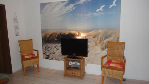 a living room with a tv and two chairs at Ferienwohnung-Hafenblick-Ueckermuende-Stettiner-Haff-Ostsee in Ueckermünde