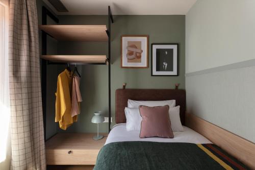 a bedroom with a bed with a green wall at TOC Hotel Las Ramblas in Barcelona