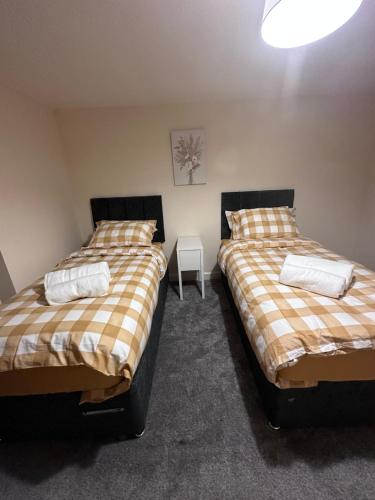 two beds sitting next to each other in a room at 2 Bed Apartment Sleeps 5, Free Parking, Free Wifi, Spacious, Quiet, Close to Station, Restaurants & Shops, Contractors and Holidays in London