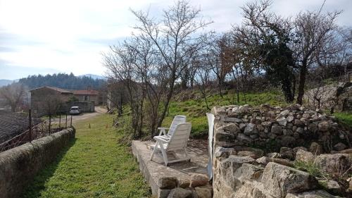 two chairs sitting next to a stone wall at ferme de fenivou in Boulieu-lès-Annonay