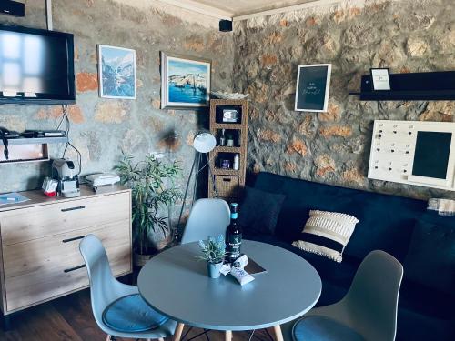 Zimmer mit einem Tisch und Stühlen sowie einem TV in der Unterkunft Kuća za odmor “Dida” in Stinica