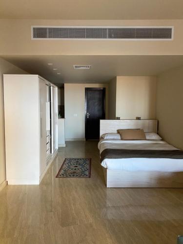 sypialnia z dużym łóżkiem i szafą w obiekcie Azzurra Sahl hasheesh w mieście Hurghada