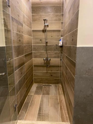 ein Bad mit einer Dusche und gefliesten Wänden in der Unterkunft Azzurra Sahl hasheesh in Hurghada