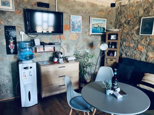 a living room with a table and a television on a wall at Kuća za odmor “Dida” in Stinica
