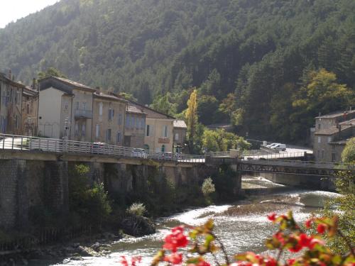 a bridge over a river in a town with buildings at L eau vive in Pontaix