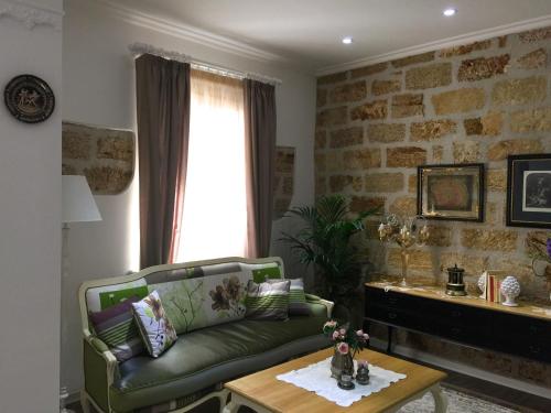 a living room with a green couch and a table at TAM Vacanze B&B in Cinisi