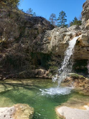 een waterval die uitmondt in een zwembad van water bij L eau vive in Pontaix