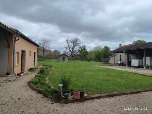 a yard next to a house with a grass yard at Chambres d hotes proche Macon in Grièges