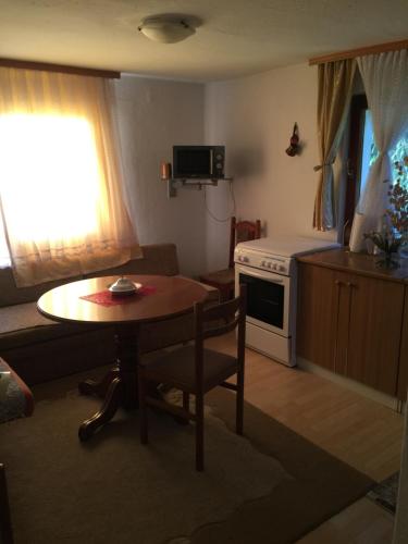 a small living room with a table and a kitchen at Dolores in Tešanj