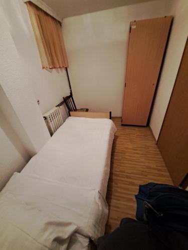 フォチャにあるRis 1の小さなベッドルーム(白いベッド1台、ドア付)