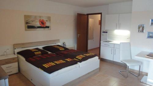 1 dormitorio con cama, mesa y cocina en FEWO-fuer-2-Pers-Hafenblick-2-Ueckermuende-Stettiner-Haff-Ostsee-direkt-Yachthafen, en Ueckermünde