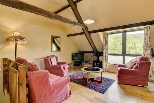 a living room with two chairs and a table at Duddings Country Cottages in Minehead