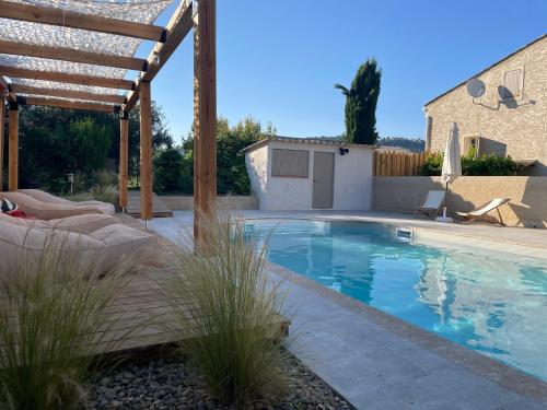 - une piscine dans un jardin avec une pergola en bois dans l'établissement Sous les étoiles en Provence, gîte les Grands chênes, à Lurs