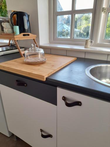 a kitchen counter with a cutting board and a sink at My Little Studio in Farmborough