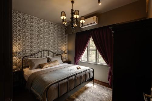 a bedroom with a bed with a chandelier and a window at Hoodo Zoe - Hebbal Bangalore Apartments in Bangalore