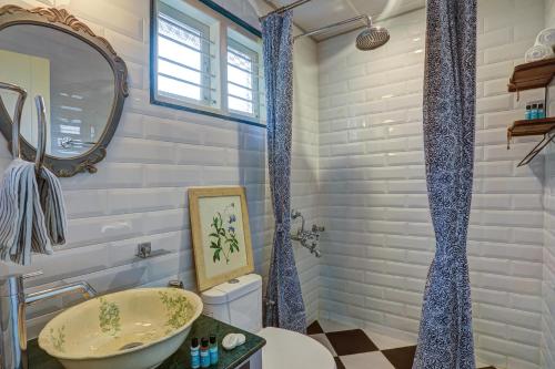 a bathroom with a sink and a toilet and a mirror at Hoodo Zoe - Hebbal Bangalore Apartments in Bangalore