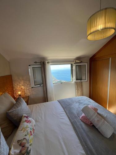 a bedroom with a large bed with a window at Tropical House in Ribeira Brava