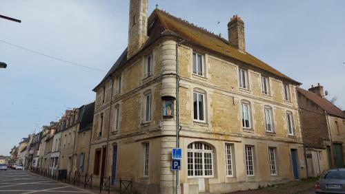 an old brick building on the side of a street at Charmant studio en centre-ville. in Saint-Pierre-sur-Dives