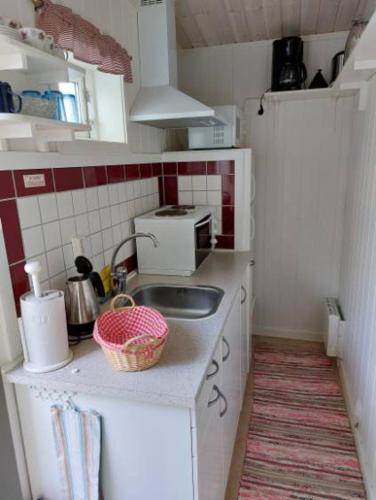 a small kitchen with a sink and a microwave at Lugnt och centralt in Strömstad