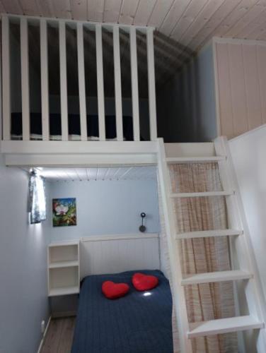 a bunk bed with two red pillows and a ladder at Lugnt och centralt in Strömstad