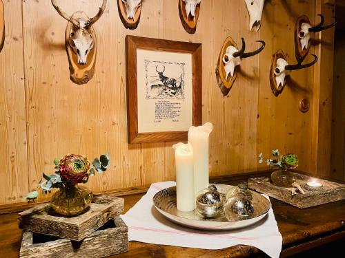 a table with a candle and skulls on a wall at Pension Möslehnerhof in Ramsau am Dachstein